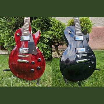 Dvě fotografie elektrických kytar typu Les Paul, jedna v červené a druhá v černé barvě. Obě mají dva humbuckery, tmavý hmatník a černý plechtrpickgua…