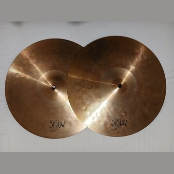 Dva mosazné činely v barvě zlata. Na levém je nápis HI-HAT TOP 13" a logo MAGIC BRONZE. Na pravém je nápis HI-HAT BOTTOM 13" a logo MAGIC BRONZE. Pov…