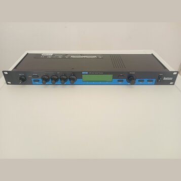 Černý rackový procesor s modrým předním panelem a LCD displejem. Na panelu je nápis MPX 500 24-Bit Dual Channel Processor a vpravo logo lexicon. Zaří…