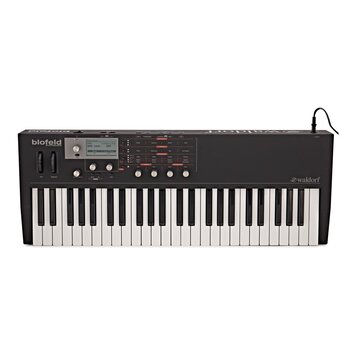 Černý klávesový syntetizátor s bílými a černými klávesami. Na levé straně horního panelu je nápis biofeld SYNTHESIZER a vpravo logo waldorf. Přístroj…