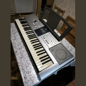 Stříbrný digitální klavír s černobílými klávesami a integrovaným reproduktorem v pravé části. Na ovládacím panelu je viditelné logo YAMAHA a displej.…