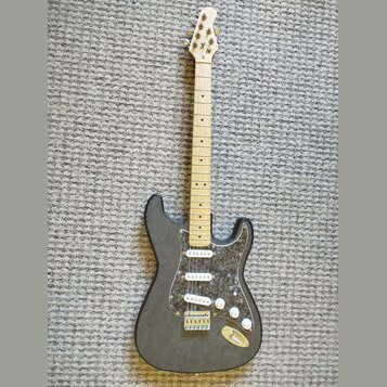 Černá elektrická kytara s tvarem typu Stratocaster a tři bílými snímači. Nástroj má světlý dřevěný hmatník a plech s tmavým mramorovaným vzorem. Na h…