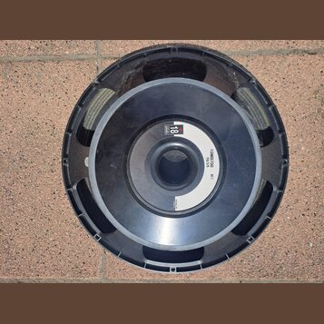 Černý reproduktor s plastovým krytem v podobě kroužku. Na horní části je logo B&C Speakers a nápis 18 SERIES. Na pravé straně je bílý text 15MB700, 1…