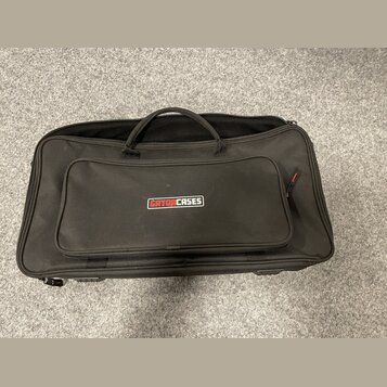 Černý textilní pouzdro s rukojetí a zipy. Na přední kapse je umístěno logo GATORCASES. Povrch materiálu vypadá čistě a bez viditelného opotřebení.