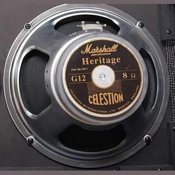 Fotografie znázorňuje reproduktor v kovovém rámu. Na středovém štítku jsou nápisy Marshall AMPLIFICATION, Heritage, Part No.S311, G12, 8 Ω a CELESTIO…