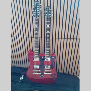 Červená elektrická kytara s dvěma hmaty a dvěma hlavami. Na obou hlavách je bílý nápis Gear4music. Nástroj má dva humbuckery, stříbrný hardware a čer…