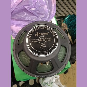 Černý reproduktor s papírovou membránou v zelené barvě. Na středovém krytu je bílý nápis JENSEN INDUSTRIES • SPEAKERS DIVISION, logo Jensen, nápisy C…