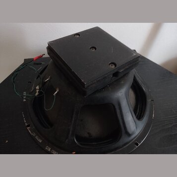 Černý reproduktor s robustním magnetem a čtvercovým horním krytem. Na spodním okrahu rámu jsou viditelné nápisy „052308“ a „C15L C0207“. Z reprodukto…
