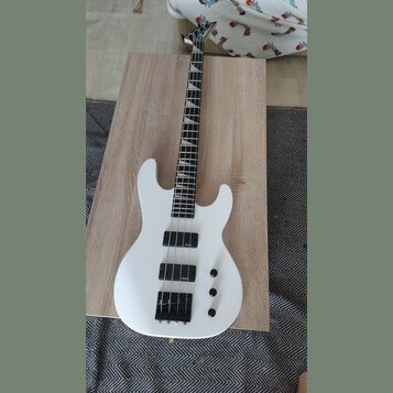 Bílá elektrická basová kytara s černým hmatníkem a černými komponenty. Na obou snímačů je viditelný nápis "schecter". Nástroj má tři ovládací knofíky…