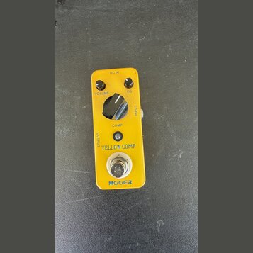 Žlutý efekt pedál s nápisy VOLUME, EQ a COMP u ovládacích knoflíků. Uprostřed je velký černý přepínač a v dolní části nápisy YELLOW COMP a MOOER. Na…