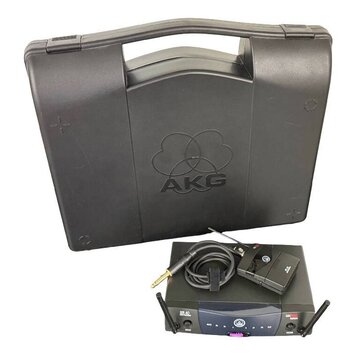 Černý plastový kufřík s vyraženým logem AKG. Před ním je umístěn bezdrátový přijímač s nápisy SR 40 a AKG Wireless System, vysílač s logem AKG a kabe…