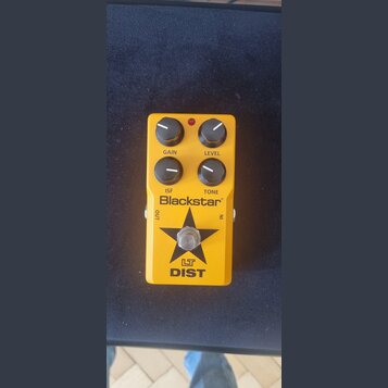 Žlutý efekt pedál s čtyřmi černými ovládacími knoflíky. Na pedálu jsou nápisy GAIN, LEVEL, ISF a TONE, logo Blackstar® a označení LT DIST pod černou…