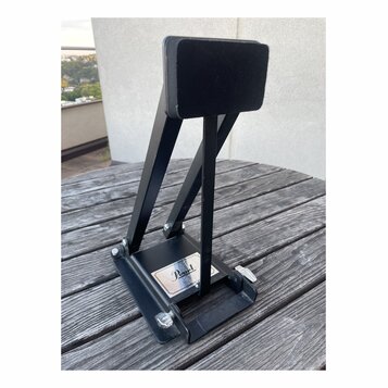 Černý kovový pedál s černou ploščkou. Na spodní základně je viditelné logo Pearl. Předmět vykazuje mírné známky opotřebení povrchu a prach.