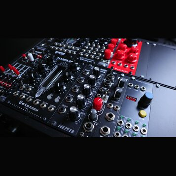 Fotografie zachycuje několik modulů Eurorack syntetizátoru v černém racku. V popředí je modul s nápisy PLASMA DP, MIXER a DOEPFER, vybavený několika…