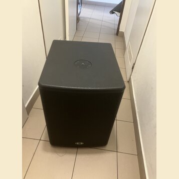 Černý subwoofer s hranatým tvarem a přední textilní maskou. Na horní straně je umístěn kruhový ovládací prvek s několika tlačítky. V dolní části před…