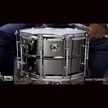 Stříbrný snare drum s chromovaným obručováním a napínacími šrouby. Na korpusu je umístěno černé kulaté logo s nápisy „Ludwig“, „Black Magic“ a „SNARE…