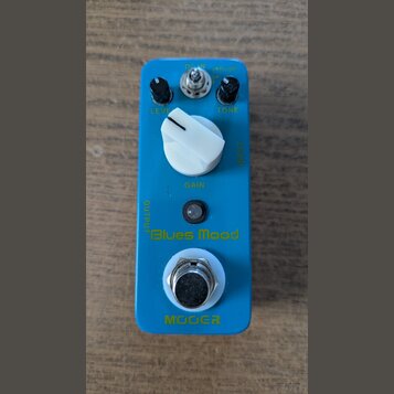 Modrý efekt pedál s nápisy „Blues Mood“ a „MOOER“. Na horní straně jsou dva černé knoflíky s popisky „LEVEL“ a „TONE“, velký bílý knoflík s popiskem…