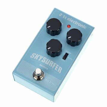 Světle modrý efekt pedál s nápisy tc electronic a SKY SURFER REVERB. Na horní straně jsou tři černé oválné ovládací knoflíky, červená kontrolka a pře…