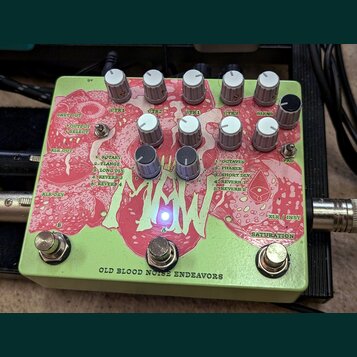 Světle zelený efekt pedál s červeným grafickým motivem. Na spodní hraně je nápis OLD BLOOD NOISE ENDEAVORS. Zařízení má deset bílých a dva černé ovlá…