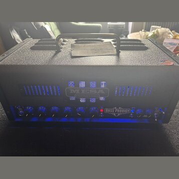 Černý basový zesilovač v texturovaném pouzdře s madlem. Na předním panelu je nápis MESA ENGINEERING a modelové označení BASS PRODIGY TUBE POWER. Zaří…