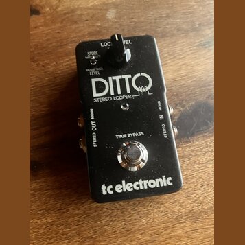 Černý kytarový pedál s nápisy DITTO STEREO LOOPER a tc electronic. Na horní části je přepínač s nápisy LOC a VEL, pod ním texty STORE a BACKING TRACK…