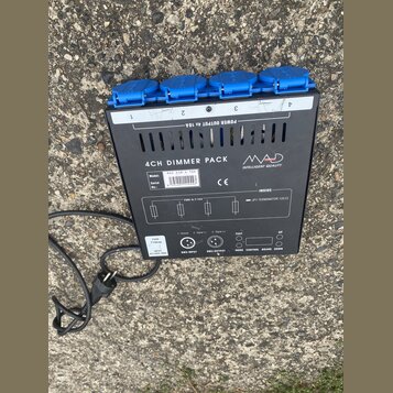 Černý čtyřkanálový dimer s modrými zásuvkami. Na zařízení je nápis 4CH DIMMER PACK a logo MAD INTELLIGENT QUALITY. Jsou zde uvedeny údaje Model: MAD…