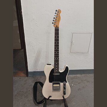 Bílá elektrická kytara s černým pickguardem a hnědým hmatníkem. Na hlavě je viditelné logo Fender. Nástroj má jeden humbucker v pozici mostu a jeden…