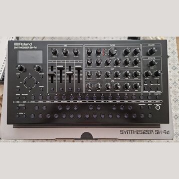Stříbrný syntetizátor s nápisy Roland SYNTHESIZER SH-4d. Přístroj obsahuje zahlreiche ovládací knoflíky, čtyři vertikální posuvníky a několik řad mal…