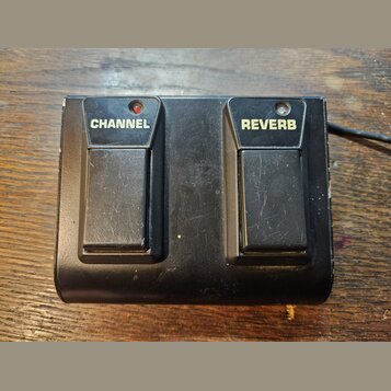 Černý dvoupedálový spínač s kovovým povrchem. Na levém pedálu je bílý nápis CHANNEL a na pravém REVERB, nad oběma se nachází kontrolní dioda. Povrch…
