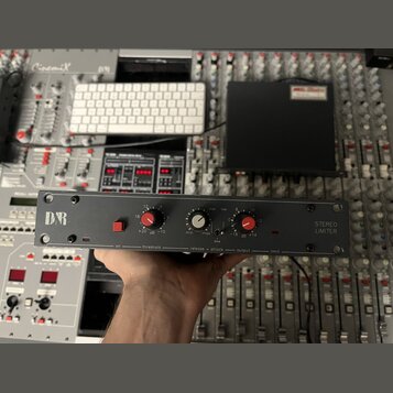 Černý rackový přístroj s nápisem STEREO LIMITER a logem D&B. Na předním panelu jsou dva červené otočné ovladače s popisky threshold a output, jeden b…