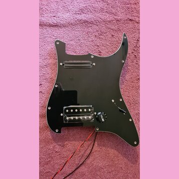 Černý plastový pickguard pro elektrickou kytaru s vyřezem na hmatník a ovládací prvky. Je vybaven jedním černým snímačem v horní části a jedním sníma…