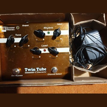 Kytarový efekt v hnědém kovovém šasi s bílými pruhy. Na přístroji jsou nápisy „Seymour Duncan“, „Twin Tube Classic“, „Rhythm“, „Lead“, „Tone“ a ovlád…