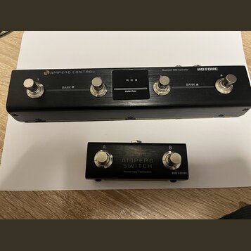 Na fotografii jsou dvě černé kovové zařízení značky HOTOHE. Horní je Bluetooth MIDI Controller s nápisem AMPERO CONTROL, čtyřmi stomačními spínači oz…