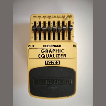 Žlutý kytarový pedál s nápisem BEHRINGER GRAPHIC EQUALIZER a označením modelu EQ700. Horní část obsahuje sedm posuvníků s popisky 100, 200, 400, 800,…