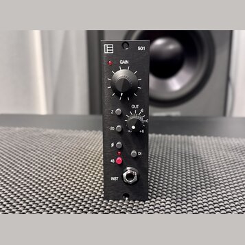 Černý rackový modul s nápisy 501, GAIN, OUT, Z, DI a INST. Na horní části je bílé logo tvořené třemi vodorovnými čarami v rámečku. Zařízení obsahuje…