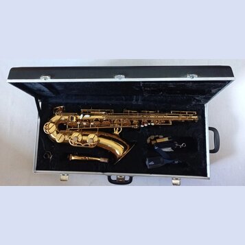 Zlatý saxofon v černém polstrovaném kufru. K nástroji je přiložen munčnípás s nápisem veti a samostatný mouthpiece. Na těle nástroje nejsou žádné čit…