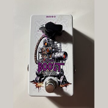 Bílý kytarový efekt pedál s grafickým motivem steampunkového stroje. Na spodní části je fialový nápis BOOST a pod ním menší text MBpedals, nad nápise…