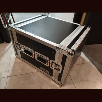 Černý transportní flightcase s hliníkovými hranami a kovovými rohy. Na přední straně jsou dvě černé plastové madla a dva kovové zámky. V dolní části…