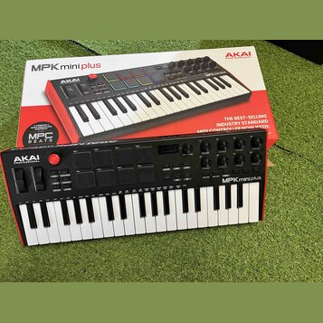 Černý MIDI kontrolér s klávesnicí, na kterém je bílým nápisem logo AKAI PROFESSIONAL a model MPK mini plus. Nástroj obsahuje barevné pady, několik ot…