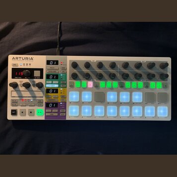 Bílá sekvenční kontrolér s názvem ARTURIA a podtitulem YOUR EXPERIENCE YOUR SOUND. Zařízení obsahuje několik řad otočných knoflíků, digitální displej…