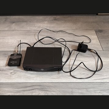 Černý bezdrátový systém složený z přijímače, vysílače a napájecího adaptéru. Na přijímači je nápis PERCEPTION wireless a SR-45, na vysílači nápisy PE…