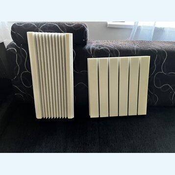 Dvě světlé akustické panely z pěny s žebrovaným povrchem. Panely mají obdélníkový tvar a jsou tvořeny svislými drážkami. Na fotografiích nejsou žádné…