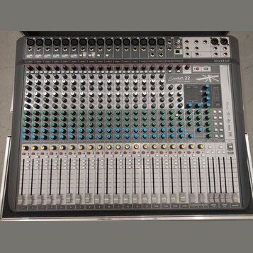 Stříbrný mixážní pult s nápisem Signature 22 MULTITRACK a logem Soundcraft v pravém horním rohu. Zařízení obsahuje numerous faders, potenciometry v b…