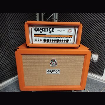 Kytarový zesilovač s oranžovým potahem, složený z hlavy a reproduktorové skříně. Na hlavě je nápis ORANGE a model ROCKERVERB 50 MK II, s řadou ovláda…