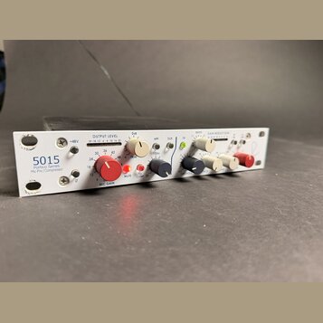 Bílý rackový zvukový procesor s nápisem 5015 Portico Series Mic Pre / Compressor. Přední panel obsahuje několik ovládacích knoflíků v červené, černé…