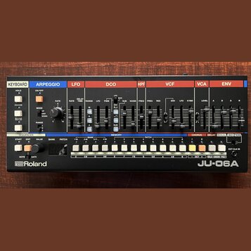 Černý syntetizátor s ovládacími prvky v horní části rozdělenými do barevných sekcí: KEYBOARD, ARPEGGIO, LFO, DCO, HPF, VCF, VCA a ENV. Na přední stra…