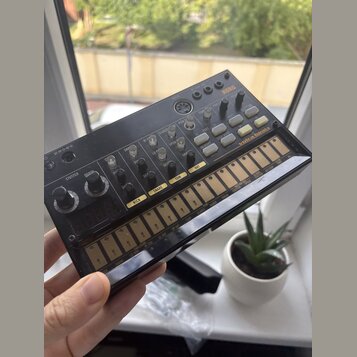 Černý elektronický sekvencer s nápisem KORG a modelem volca beats. Zařízení obsahuje řadu ovládacích knofíků, tlačítek a spodní sekvencer s označeným…