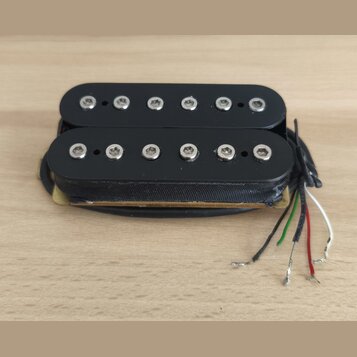 Černý humbucker s dvěma řadami šesti kovových pólů. Nástroj nemá žádné viditelné značky ani nápisy. Z pravé strany vedou čtyři barevné vodiče (černý,…