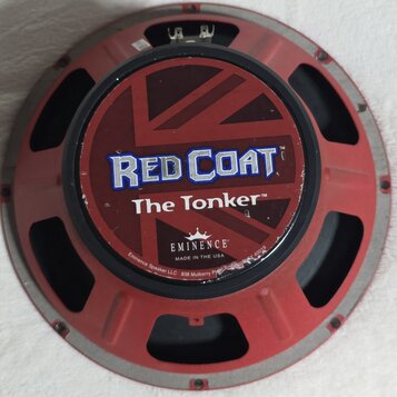 Kruhový reproduktor s červeným rámem. Na středovém krytu je nápis RED COAT a The Tonker, pod kterým je logo EMINENCE a text MADE IN THE USA. Na okraj…