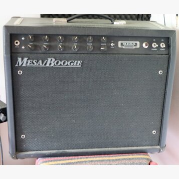 Černý kytarový kombozesilovač s látkovým předním krytem. Na krytu je bílý nápis Mesa/Boogie a v horním ovládacím panelu se nachází logo MESA. Panel o…